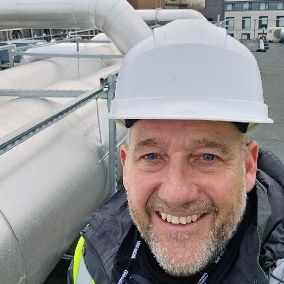 David Peck on site with insulated pipework installation behind
